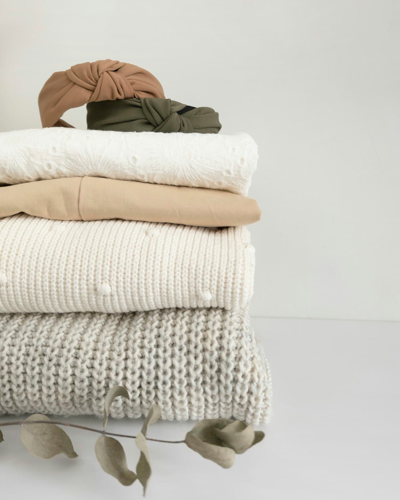 A neat stack of folded knitwear in soft neutrals